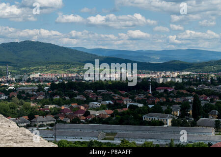 Die Dächer der Stadt beherbergt unter grünen Bäumen an einem bewölkten Tag im Sommer mit viel Wolken am Himmel. . Für ihr Design Stockfoto