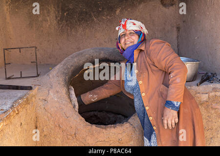 Lokale Frau, die Brot im Tandoor Ofen backen, in Rayen, Iran. Stockfoto