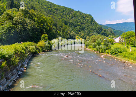 Berg raschen und schnellen Fluss zwischen den Steinen entlang der grünen Hang ausgeführt wird. Für ihr Design Stockfoto