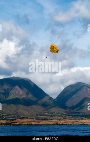 Tandem parasailers Gleiten über der Westküste von Maui. West Maui Berge im Hintergrund. Stockfoto