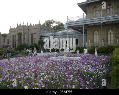 Das blumenbeet vor der alten Palast ist dicht mit weißen und violetten Petunien gepflanzt. Für ihr Design Stockfoto