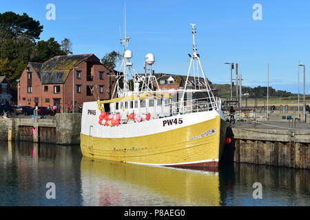 Ein großes Fischerboot günstig in Padstow Harbour, Cornwall, England an einem heißen Sommertag mit einem tiefblauen Himmel und das Boot im Wasser wider. Stockfoto