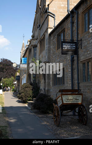 Broadway Museum und Kunstgalerie in den Cotswolds, Vereinigtes Königreich. Broadway Dorf liegt unter Fisch Hill auf der westlichen Cotswold Escarpment. Der "breite Weg" ist die breite Gras gesäumten Hauptstraße, zentriert auf dem Grün, der mit roten Kastanien und Honig gesäumt ist - farbige Cotswold Kalkstein Gebäude, viele, die aus dem 16. Jahrhundert. Es ist für seine Assoziation mit der Kunst und Handwerk Bewegung bekannt und liegt in einer Gegend von herausragender Landschaft und Naturschutz. Die breite Hauptstraße mit einer Vielzahl von Geschäften und Cafés gesäumt ist, viele in denkmalgeschützten Gebäuden untergebracht. Die Cotswolds sind ein Stockfoto