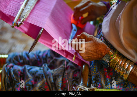 Ein kayan Frau (lange Hals Personen) Weben Seide auf einer hölzernen, Inle Lake, Myanmar Webstuhl. Stockfoto