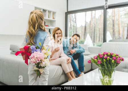 Selektiver Fokus der kleinen Tochter mit Geschenken für mathers Tag und Eltern auf dem Sofa zu Hause Stockfoto