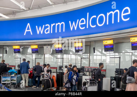 Die Passagiere am British Airways Check-in Schalter am Flughafen Heathrow Terminal 5 wartet unter ein willkommenes Zeichen Stockfoto