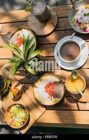 Blick von oben auf die Ananas, köstlichen tropischen Cocktails und Snacks auf hölzernen Tisch Stockfoto