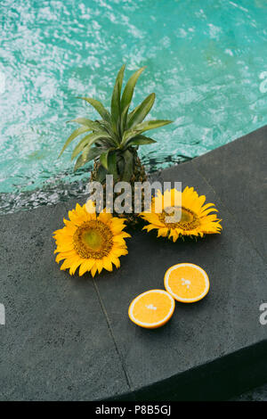 Der Ananas, enger geschnittene orange und schönen gelben Blumen am Pool Stockfoto