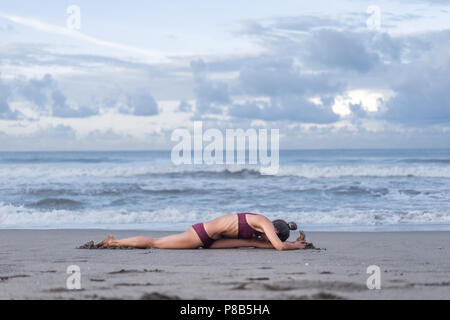 Seitenansicht der jungen Frau Yoga vor Splits darstellen (Hanumanasana) an der Küste Stockfoto