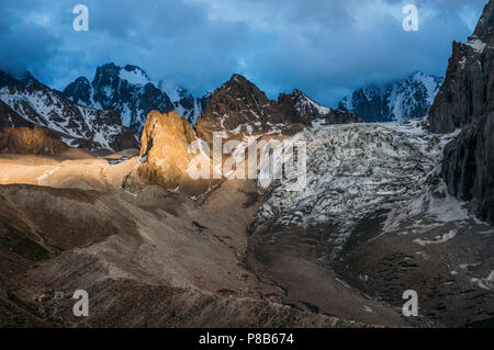 Der felsige Gipfel mit Schnee unter stürmischen Wolken und teilweise Sonne Licht auf Gelände, Ala Archa Nationalpark, Kirgisistan Stockfoto