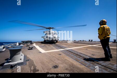 180623-N-LI 768-1067 PAZIFISCHEN OZEAN (23. Juni 2018) - der bootsmann Mate 3. Klasse Aaliyah Terrell, der Geführten zugeordnet Anti-raketen-Zerstörer USS Dewey (DDG105), steht als MH-60R Sea Hawk Hubschrauber zum 'Magicians" der Hubschrauber Maritime Strike Squadron (HSM) 35 zugewiesen, bereitet sich auf den Start, 23. Juni 2018. Dewey ist unterwegs in den USA 3 Flotte Bereich der Operationen. (U.S. Marine Foto von Mass Communication Specialist 2. Klasse Devin M. Langer/Freigegeben). () Stockfoto