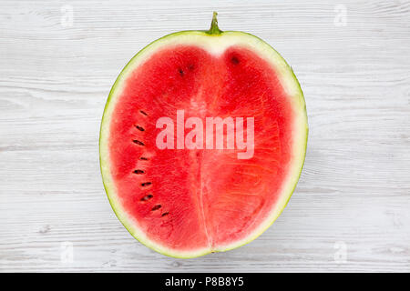 Die Hälfte geschnittenen Wassermelone auf weißem Holz- Oberfläche, Ansicht von oben. Von oben. Stockfoto