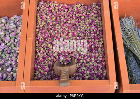 Getrocknete rote Rosen aromatische Rosenblütenblätter und andere Gewürze zum Verkauf in Holzkisten. Stockfoto