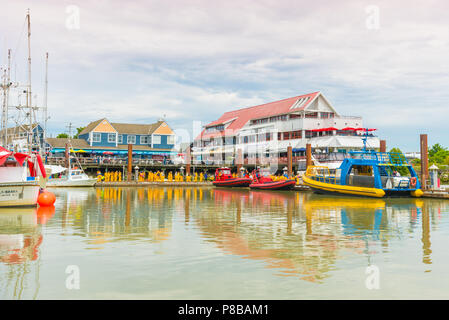 Steveston, British Columbia/Kanada - 24. Juni 2018: Touristen in den wasserdichten Gang warten in der Linie von Fisherman's Wharf und Restaurants, Vorbereiten der Bo Stockfoto