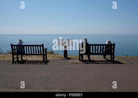 Beachgoers genießen das warme Wetter in Großbritannien, mit Blick aufs Meer in Budleigh Salterton, Devon, Großbritannien Stockfoto