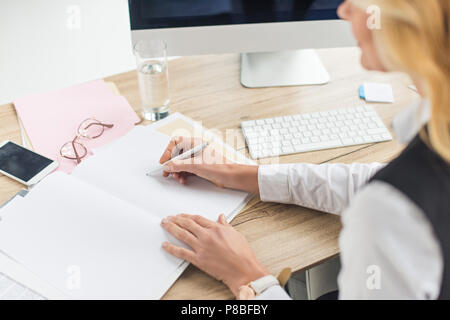 Schuss Geschäftsfrau Schreibarbeit tun am Arbeitsplatz 7/8 Stockfoto