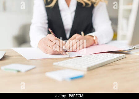 Schuss Geschäftsfrau Schreibarbeit tun am Arbeitsplatz 7/8 Stockfoto
