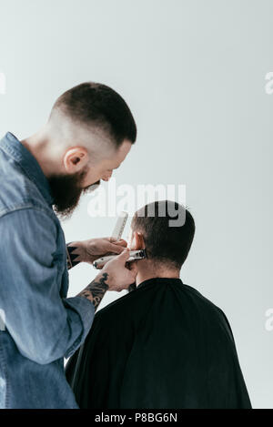 Ansicht der Rückseite des Friseur rasieren Kunden Haar an Barbershop isoliert auf weißem Stockfoto