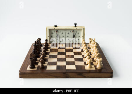 Schachuhr und Board mit Schachfiguren isoliert auf weißem Stockfoto