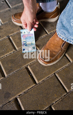 Die Suche nach einer Banknote auf der Straße Stockfoto