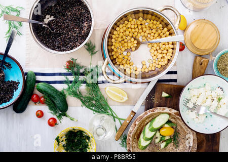 Zutaten für Kochen gesund Salat mit schwarzen Quinoa, Kichererbse, Feta Käse und Gemüse auf Holztisch, Ansicht von oben. Gesunde Ernährung Konzept Stockfoto