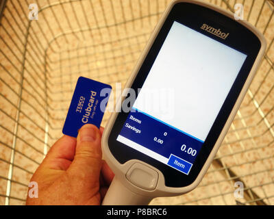 Der Mensch beginnt, sein Einkaufen bei Tesco über die seine Clubcard Mitgliedskarte der Scan zu verwenden, wie Sie shop Routine Stockfoto