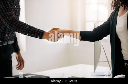 Nahaufnahme von Geschäftspartnern zitternden Hand. Unternehmer Unternehmer wünscht eine Frau an seinem Tisch im Amt. Stockfoto