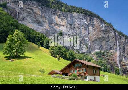 Blick auf einem Bauernhof in der Nähe von Lauterbrunnen und mit Staubbachfall im Hintergrund, Interlaken-Oberhasli, Bern, Schweiz Stockfoto