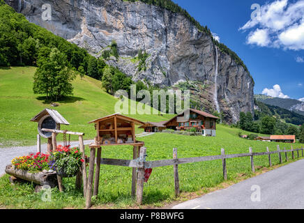 Blick auf einem Bauernhof in der Nähe von Lauterbrunnen und mit Staubbachfall im Hintergrund, Interlaken-Oberhasli, Bern, Schweiz Stockfoto