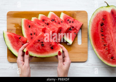 Frauen Hände halten ein Stück Wassermelone, Ansicht von oben. Stockfoto