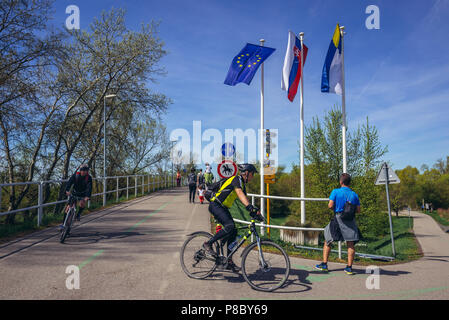 Radfahrer auf eine Freiheit Radfahren Brücke überspannt den Fluss Morava zwischen der Slowakei und Österreich Stockfoto