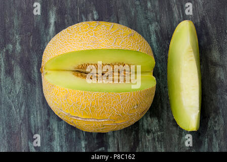 Frische Melone in kleine Stücke schneiden auf Holztisch. Direkt oben betrachten. Stockfoto