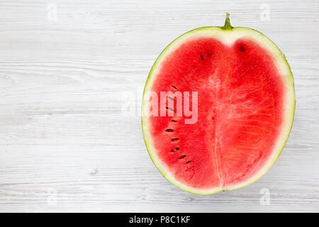 Die Hälfte geschnittenen Wassermelone auf weißem Holz- Hintergrund. Kopieren Sie Platz. Stockfoto