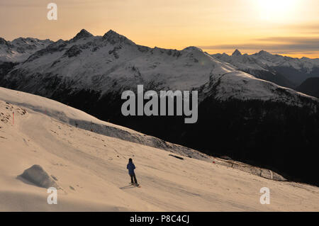 Davos-City: Ein einsamer Snow-boarder Fahren hinunter Jakobshorn bei Sonnenuntergang Stockfoto