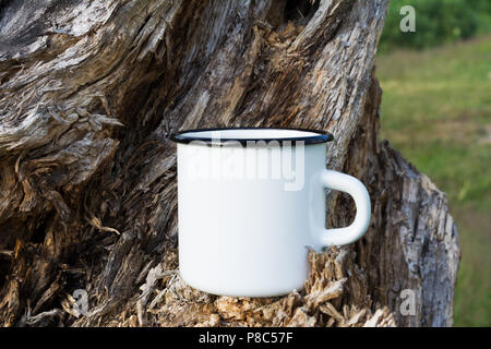 Weiß Lagerfeuer Emaille Tasse mockup mit alten verwitterten Stumpf. Leere Becher mock up für Design Promotion. Stockfoto