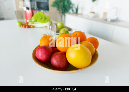 Volle Schüssel frisches Obst (Äpfel, Orangen, Pampelmusen und Grapefruits) in die Küche zu Hause. Gesunde Ernährung Konzept Stockfoto