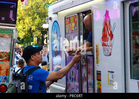 Eine Person, die den Kauf einer weichen von einem New York Marke ice cream Truck dienen Stockfoto