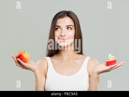 Übergewicht, gesunde Ernährung und Diät Konzept. Frau mit gesunden und ungesunden Essen. Schwierige Wahl. Stockfoto