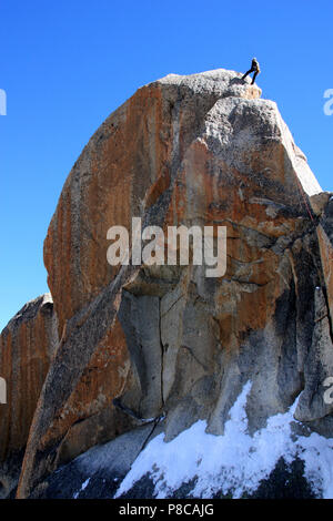 Ein Kletterer auf eine beeindruckende Felsen neben den Gipfel der Aiguille-du-Midi in das Mont Blanc Massiv, Frankreich Stockfoto