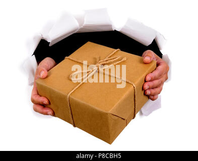 Man Hände liefern oder das Paket durch zerrissenen weißen Papier Hintergrund Stockfoto