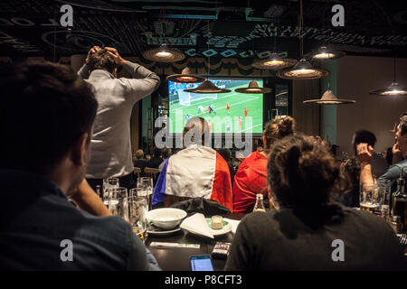 Bild einer Gruppe französischer Anhänger in einem Restaurant auf einem riesigen Bildschirm die semi Finale Frankreich Belgien, während der FIFA WM 2018, welche den Sieg der französischen Mannschaft gesehen. Die 2018 FIFA World Cup ist der 21 FIFA World Cup, ein Internationales Fußball-Turnier, das von nationalen der Männer Teams der Mitgliedsverbände der FIFA alle vier Jahre einmal bestritten. Es ist derzeit in Russland ab 14. Juni und wird mit dem Finale am 15. Juli 2018 Stockfoto