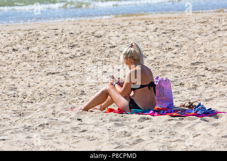 Bournemouth, Dorset, Großbritannien. 11. Juli 2018. UK Wetter: Ein anderes heißen, sonnigen Tag in Bournemouth mit kein Zeichen der Hitzewelle noch beenden, als Sonnenanbeter Kopf ans Meer in Bournemouth Strände. Frau sonnenbaden. Credit: Carolyn Jenkins/Alamy leben Nachrichten Stockfoto