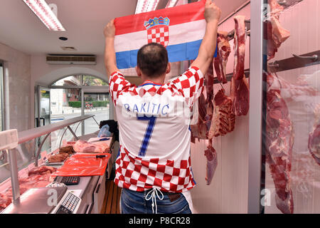 Sibenik, Kroatien. 11. Juli 2018. Metzger Mario Samodol tragen ein Trikot der kroatischen Nationalmannschaft zeigt eine Nationalflagge Kroatiens auf eine Metzgerei im Vorfeld der FIFA WM Halbfinale zwischen Kroatien und England in Sibenik, Kroatien, am 11. Juli 2018. Credit: Hrvoje Jelavic/Xinhua/Alamy leben Nachrichten Stockfoto