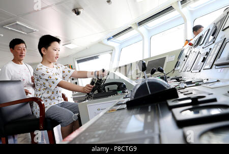 Shanghai. 11. Juli 2018. Ein Junge sitzt auf dem Pilotensitz an Bord der Dong Hai Jiu 101 Rettung Schiff während ein Schiff Tag der offenen Aktivität die 2018 Tag der Meere von China Kennzeichnung im Osten Chinas Shanghai, 11. Juli 2018. Die 2018 Tag der Meere von China wurde am Mittwoch beobachtet. Credit: Fang Zhe/Xinhua/Alamy leben Nachrichten Stockfoto