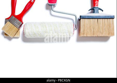 Blick von oben auf die Pinsel und Roller für professionelle Maler, auf weißem Hintergrund fotografiert. Stockfoto