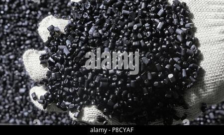 Kunststoff schwarz grau granulierten Crumb. Herstellung von Wasserleitungen aus Kunststoff Fabrik. Prozess, in dem die Kunststoffe an der Werkzeugmaschine mit der Nutzung von Wasser- und Luftdruck. Stockfoto