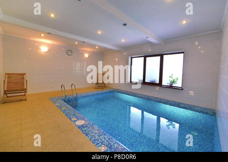 Ein kleiner Pool von Blau und zwei hölzerne Klappstühle. Für ihr Design Stockfoto