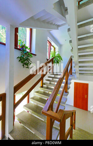 Steinerne Treppe mit Holzgeländer im Flur des Hotelkomplexes. Für ihr Design Stockfoto