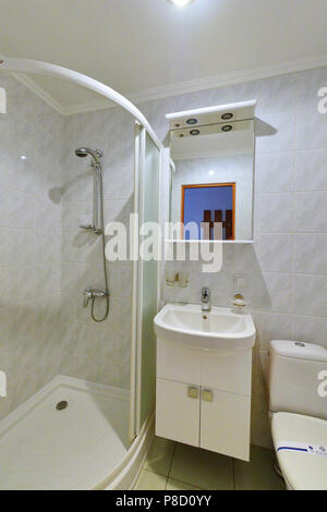 Kombinierte Bad mit Europäischen hochwertige Sanierung mit weißen Fliesen ausgelegt gestreckt Decke Dusche und moderne Ausstattung. . Für ihr Design Stockfoto