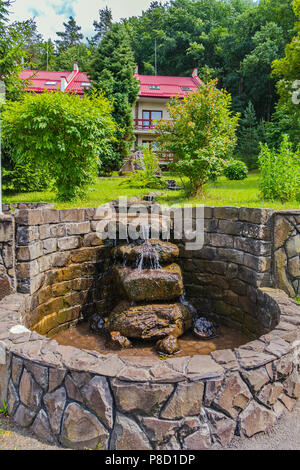 Ein Miniatur Wasserfall in Form von einem Strom von Wasser laufen nach unten über die Steine von Hand verlegt. . Für ihr Design Stockfoto